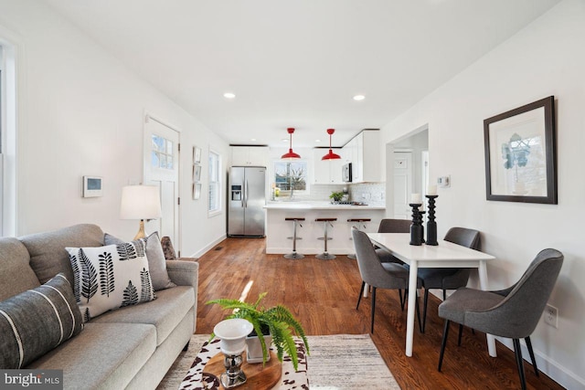 living area featuring recessed lighting, baseboards, and wood finished floors