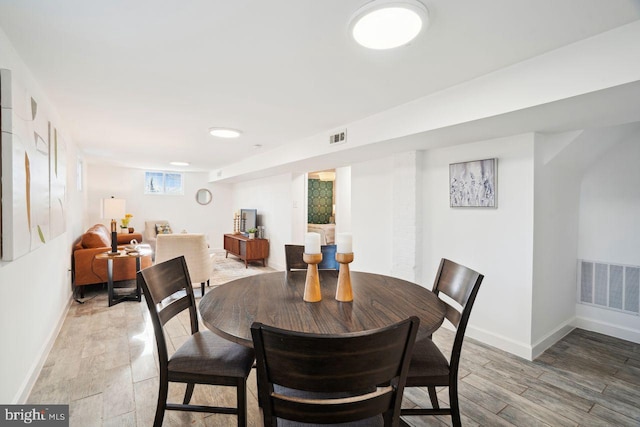 dining area with visible vents, baseboards, and light wood finished floors