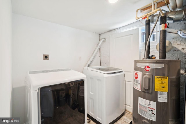 laundry room featuring laundry area, washing machine and clothes dryer, light wood finished floors, and electric water heater