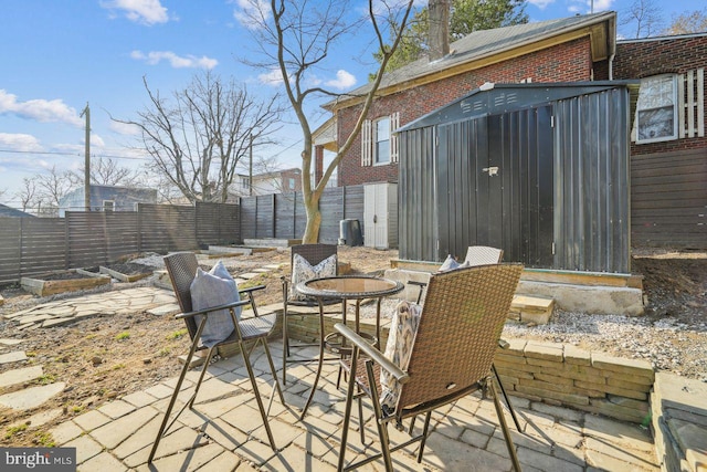 view of patio featuring a garden and fence