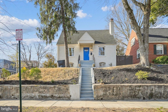 view of front of property with brick siding and a chimney