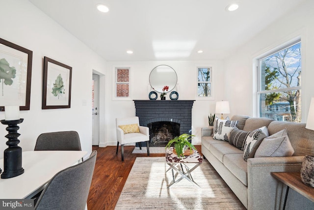 living area with dark wood-type flooring, recessed lighting, and a fireplace