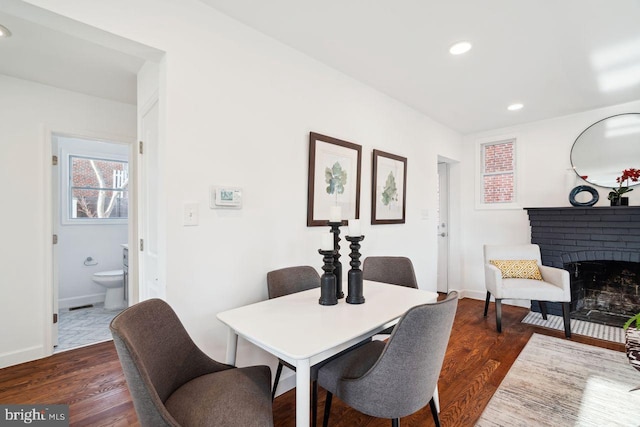 dining space with dark wood-style floors, recessed lighting, a fireplace, and baseboards