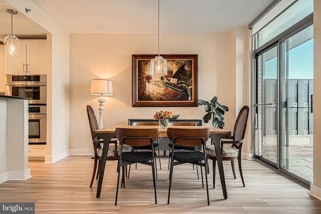 dining area featuring baseboards and light wood-style floors