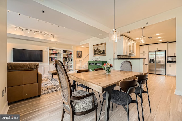 dining room with recessed lighting, stairway, and light wood finished floors