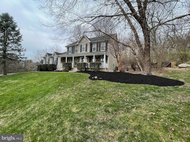 colonial home featuring covered porch and a front lawn