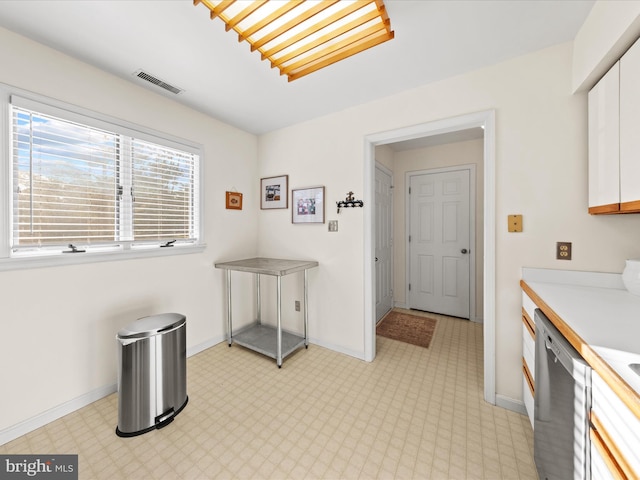 kitchen with visible vents, light floors, light countertops, white cabinets, and stainless steel dishwasher