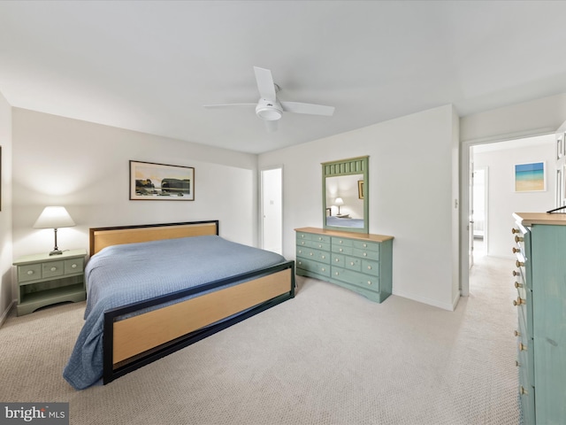 bedroom featuring light colored carpet, baseboards, and ceiling fan