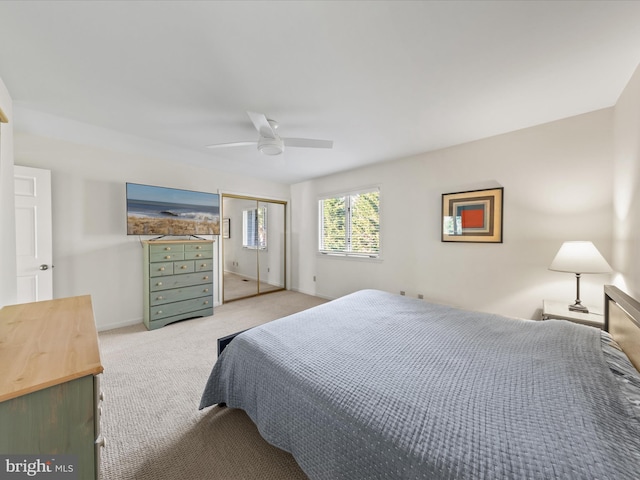 bedroom featuring light carpet, ceiling fan, a closet, and baseboards