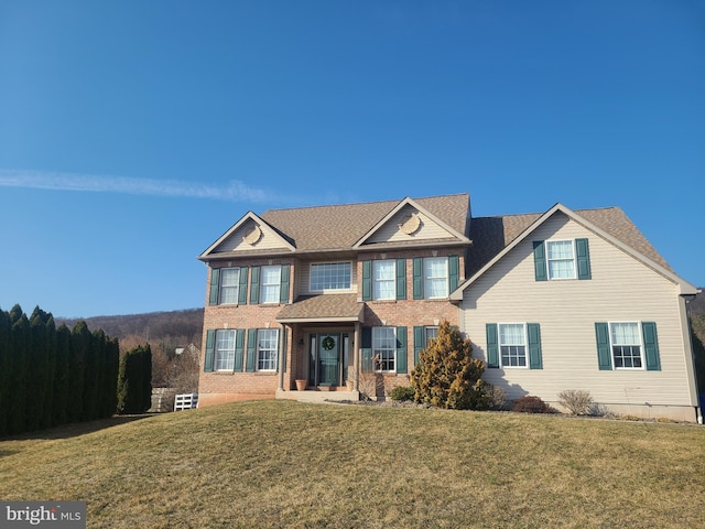 view of front of house featuring brick siding and a front lawn