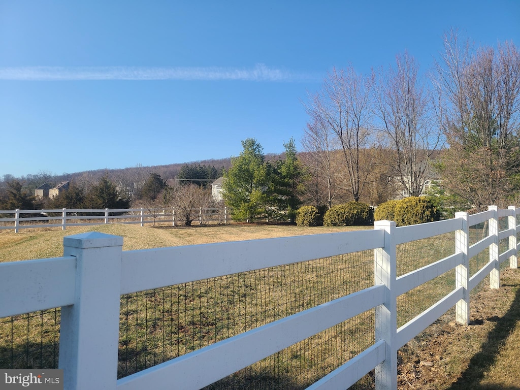 view of yard with a fenced front yard and a rural view