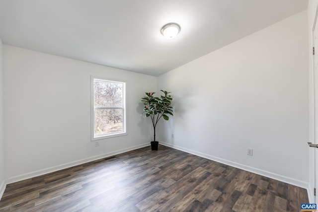 unfurnished room with baseboards and dark wood-style flooring