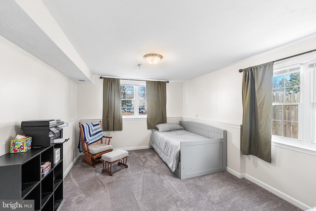 carpeted bedroom with baseboards and multiple windows