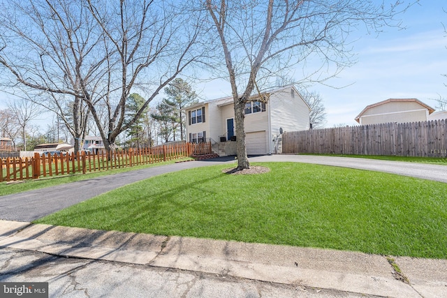 view of yard featuring a fenced front yard and driveway