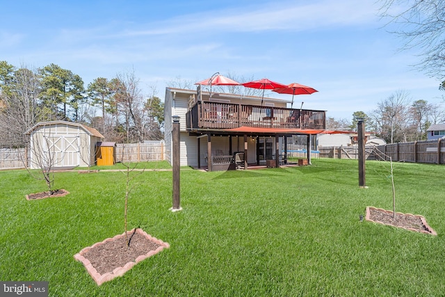 rear view of property with a shed, a fenced backyard, a yard, an outdoor structure, and a deck