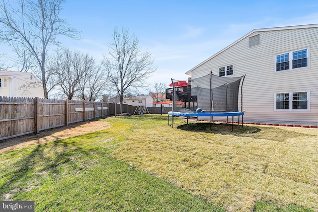 view of yard featuring a trampoline and a fenced backyard