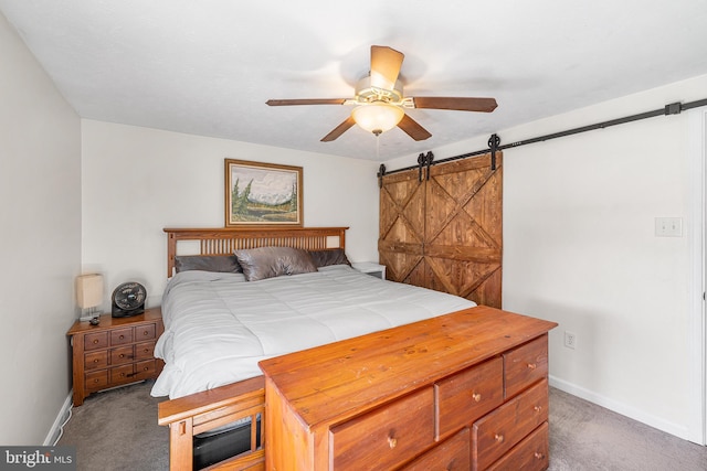 bedroom with ceiling fan, baseboards, a barn door, and carpet floors