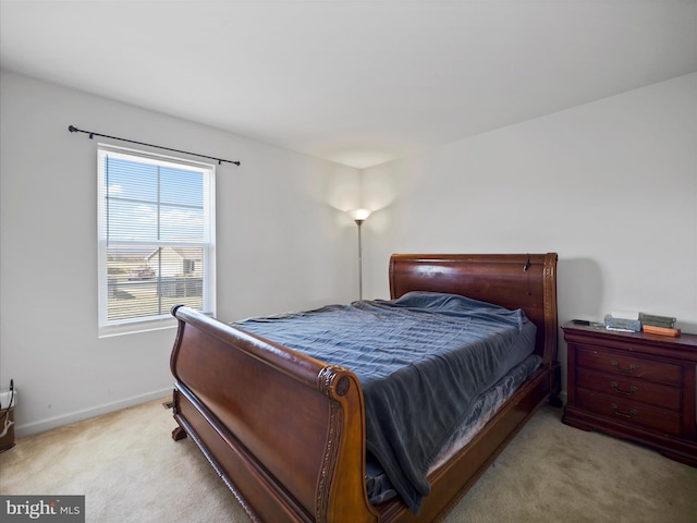 bedroom with light colored carpet and baseboards