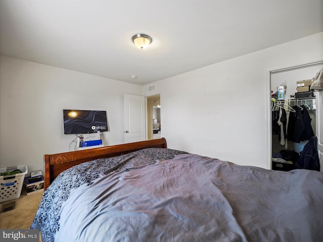 bedroom with a spacious closet, carpet, visible vents, and a closet