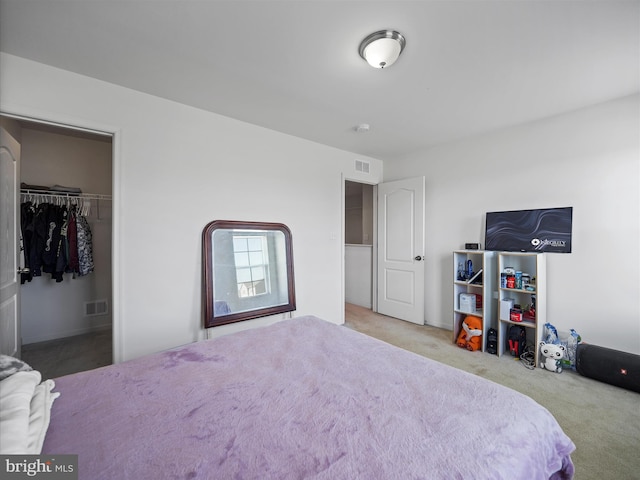 carpeted bedroom with a spacious closet and visible vents