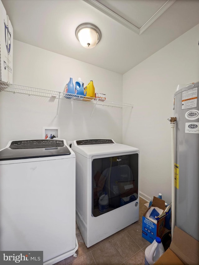 laundry room featuring washing machine and clothes dryer, laundry area, electric water heater, and dark tile patterned flooring