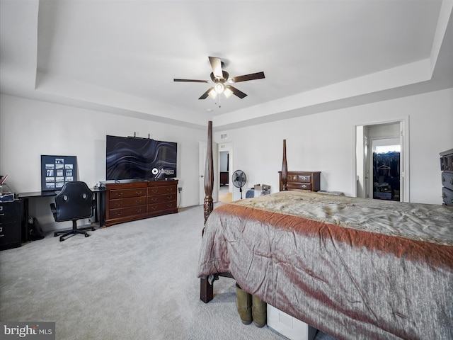 carpeted bedroom featuring a raised ceiling and ceiling fan