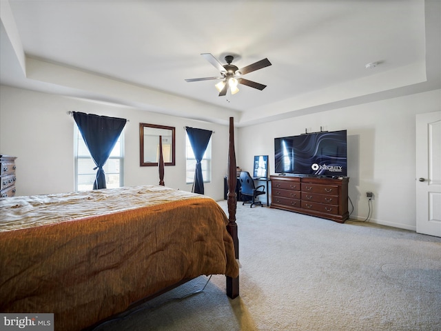 bedroom with baseboards, carpet flooring, a ceiling fan, and a tray ceiling