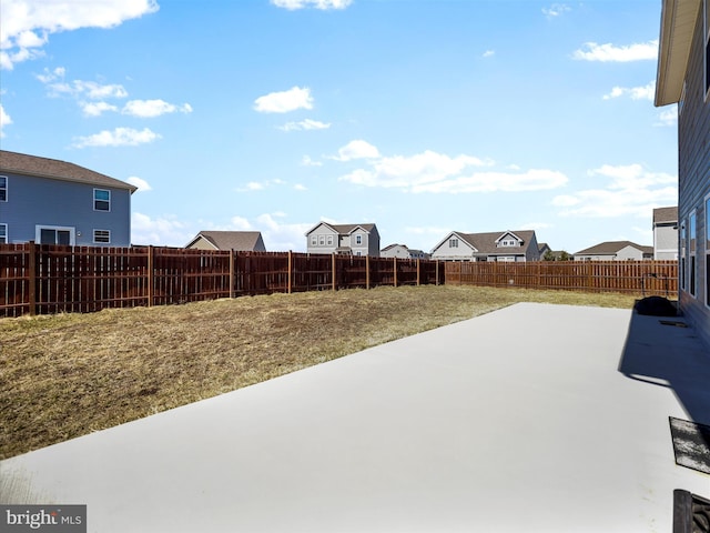 view of yard with a patio area, a residential view, and a fenced backyard