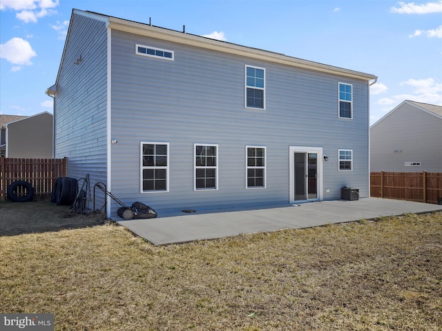 rear view of property featuring a yard, a patio, and fence