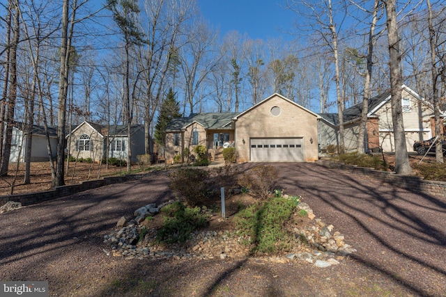 view of front facade with aphalt driveway, a garage, and stucco siding