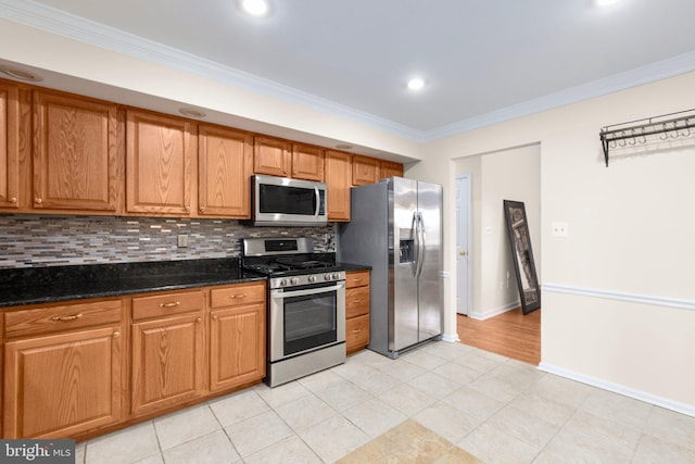 kitchen with tasteful backsplash, appliances with stainless steel finishes, crown molding, and baseboards