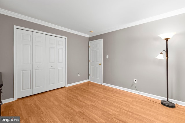 unfurnished bedroom with a closet, baseboards, light wood finished floors, and ornamental molding