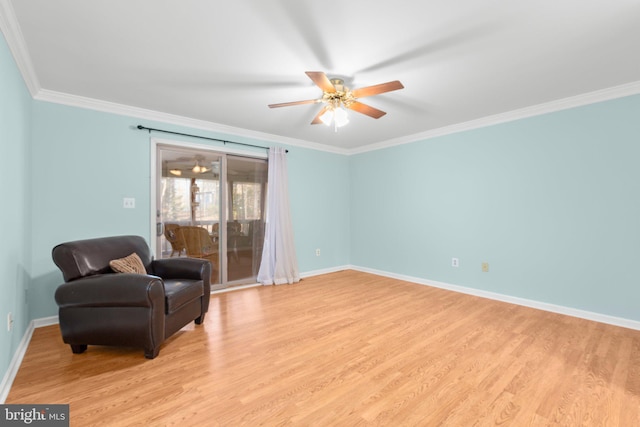 sitting room with baseboards, crown molding, and light wood-style floors