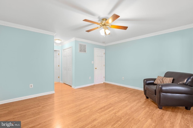 sitting room with visible vents, baseboards, ornamental molding, light wood-style floors, and a ceiling fan