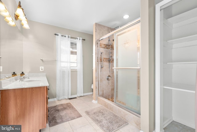 full bathroom with tile patterned flooring, a shower stall, baseboards, toilet, and vanity