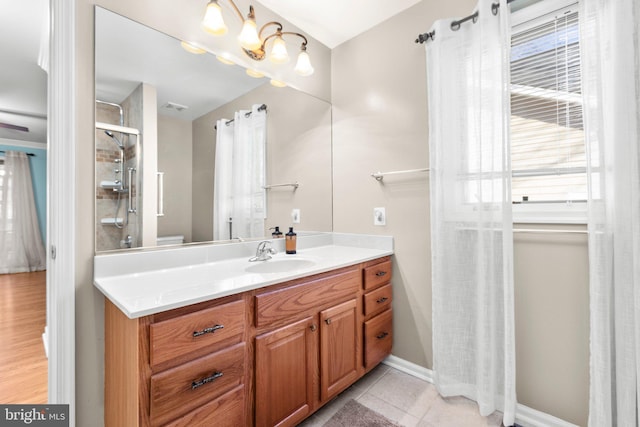 bathroom with tile patterned floors, vanity, a shower, and baseboards