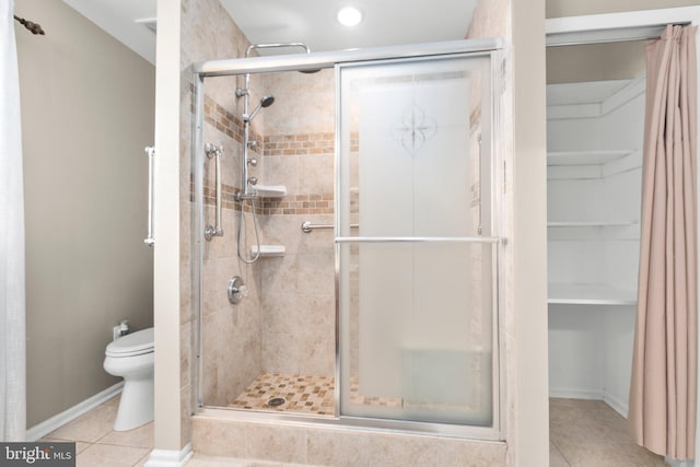 full bath featuring tile patterned floors, baseboards, toilet, and a shower stall