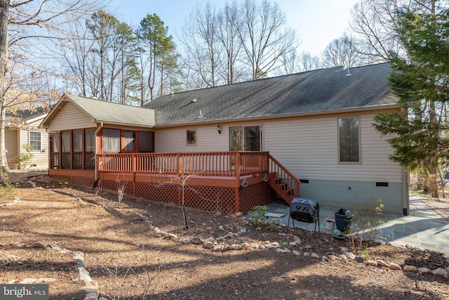 back of property with crawl space, a wooden deck, a shingled roof, and a sunroom