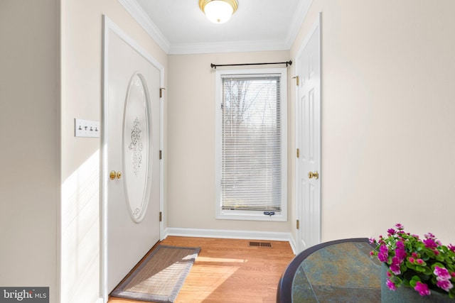 entryway with visible vents, baseboards, crown molding, and light wood finished floors