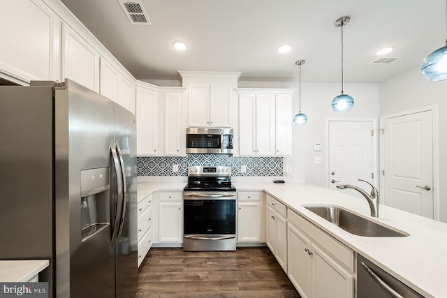 kitchen featuring decorative backsplash, visible vents, appliances with stainless steel finishes, and a sink