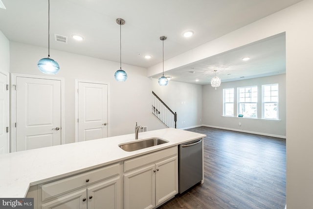 kitchen featuring a sink, decorative light fixtures, stainless steel dishwasher, and light countertops