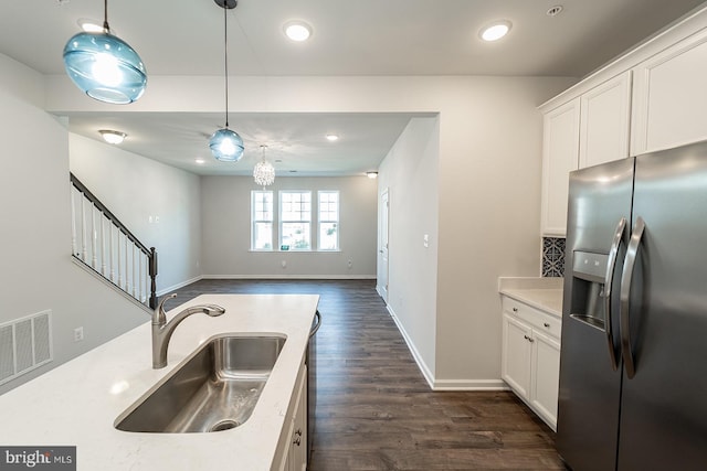 kitchen with visible vents, a sink, open floor plan, white cabinetry, and stainless steel fridge