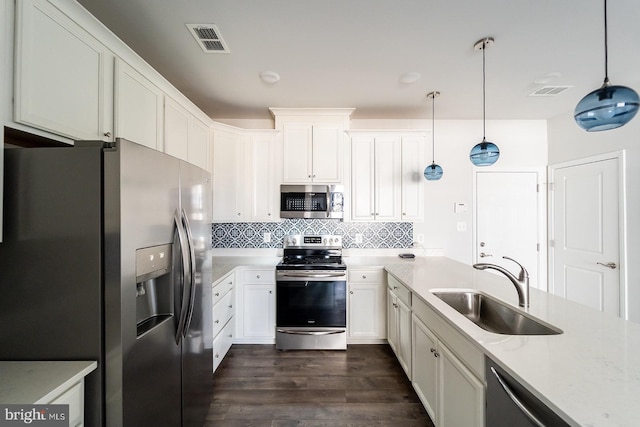 kitchen with visible vents, backsplash, a sink, appliances with stainless steel finishes, and dark wood-style flooring