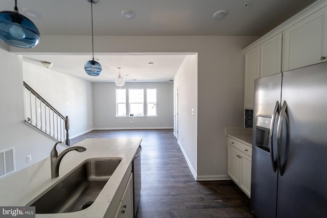 kitchen with dark wood-style floors, white cabinets, appliances with stainless steel finishes, and a sink