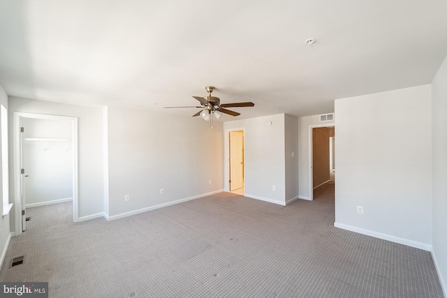 interior space with a spacious closet, visible vents, baseboards, and carpet