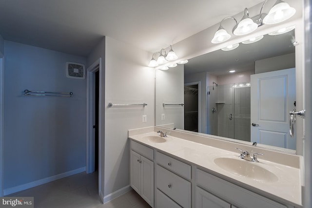 full bathroom with double vanity, baseboards, a stall shower, and a sink