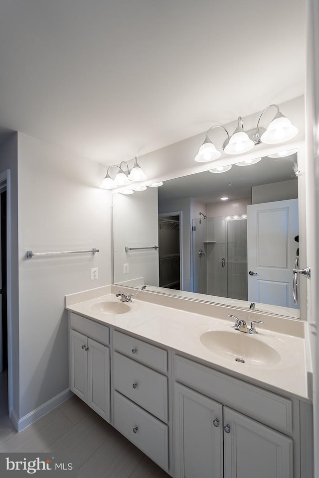 bathroom with double vanity, a stall shower, and a sink