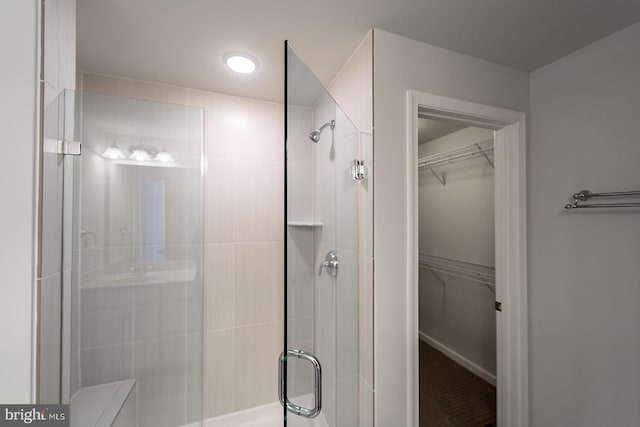 full bathroom with a stall shower and a walk in closet