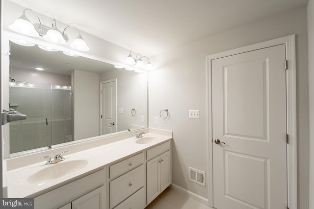 full bath featuring a sink, visible vents, a shower stall, and double vanity