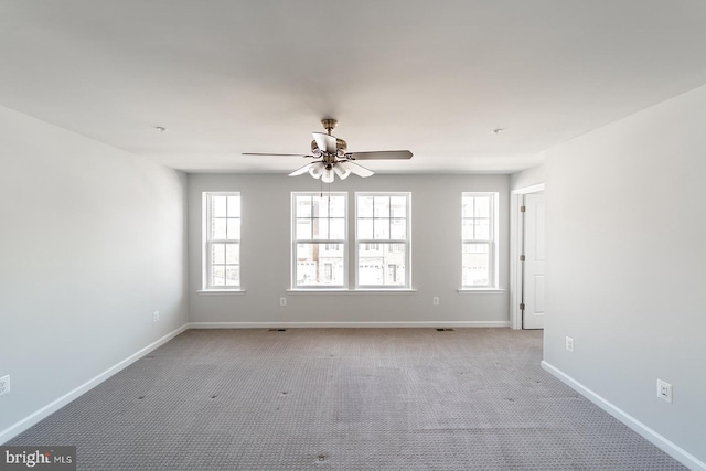 unfurnished room with light carpet, a ceiling fan, and baseboards